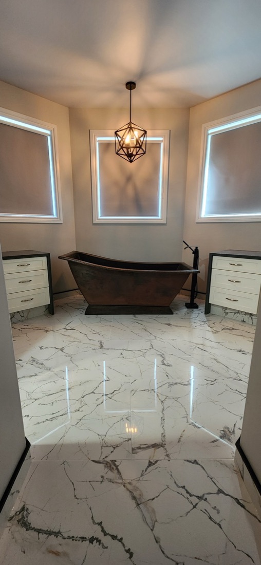 Polished white large-format bathroom floor leading to the copper bathtub in Copper Elegance