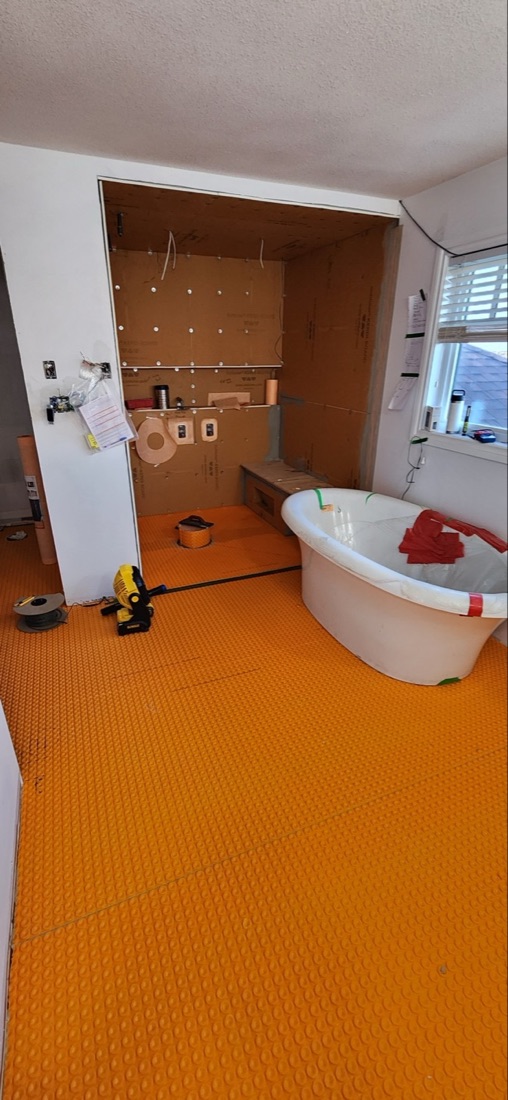 Schluter membrane and shower preparation extending across the Luminous Smoke ensuite before tile installation