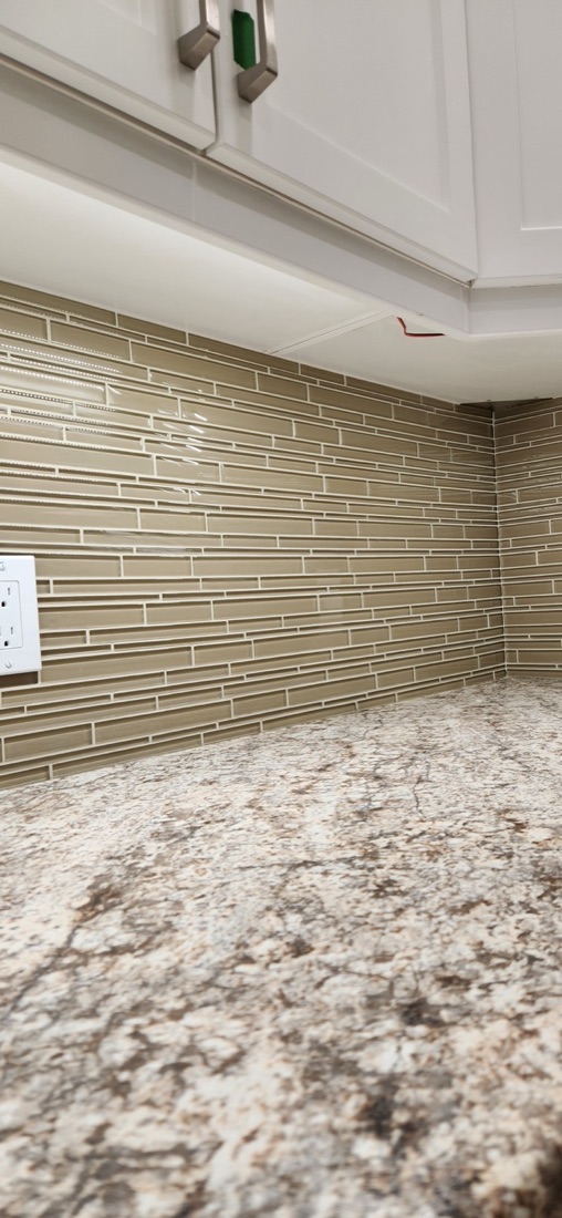 Warm Glass Mosaic backsplash with narrow glass tiles, grout joints and the adjoining kitchen countertop
