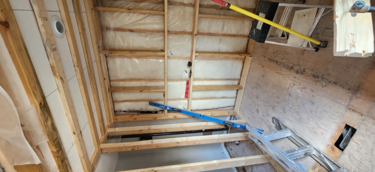 Open framing and a blue carpenter’s level during ensuite preparation